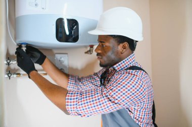 Professional engineer installing a natural gas boiler at home, he is checking the pipes.