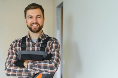 İnşaat alanında çalışırken genç ve yakışıklı bir inşaatçının portresi.