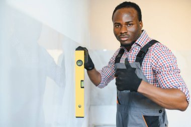 Afrikalı Amerikalı İşçi duvar kiremiti yerleştiriyor..