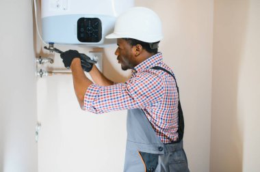 Professional engineer installing a natural gas boiler at home, he is checking the pipes.