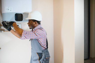 Professional engineer installing a natural gas boiler at home, he is checking the pipes.