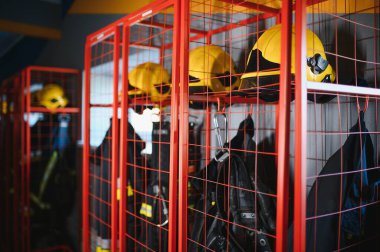 Kask ve üniformaları itfaiyeciler, soyunma odasında.