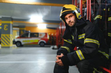 İtfaiyeci itfaiyede bankta oturuyor..