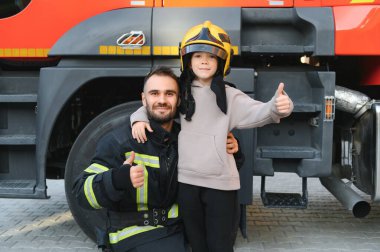 İtfaiyeci çocuğu ateşten ve dumandan kurtarmak için tutuyor. İtfaiyeciler çocukları ateşten kurtarıyor..