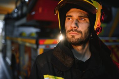 Depresyonda ve yorgun itfaiyeci itfaiye arabasının yanında.