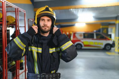 İtfaiye istasyonunda koruyucu üniforma giyen itfaiyeci..