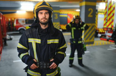 İtfaiyecinin biri itfaiyede üniforma giyiyor..