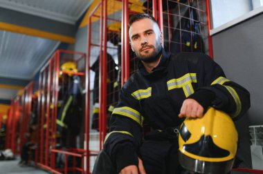 İtfaiyeci itfaiyede bankta oturuyor..