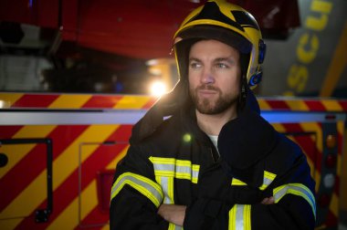 İtfaiyeciler itfaiye aracının yanındaki koruyucu kıyafetli adam. Koruma, tehlikeden kurtarma. İtfaiye.