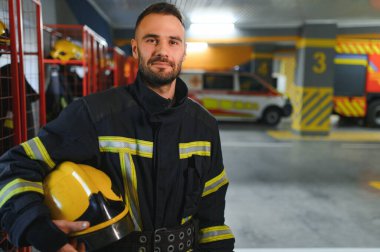 İtfaiyecinin biri itfaiyede üniforma giyiyor..