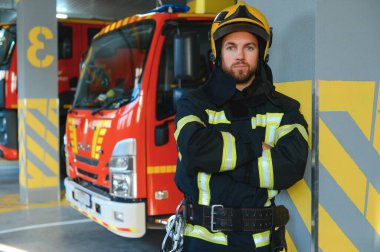 İtfaiyeciler itfaiye aracının yanındaki koruyucu kıyafetli adam. Koruma, tehlikeden kurtarma. İtfaiye.