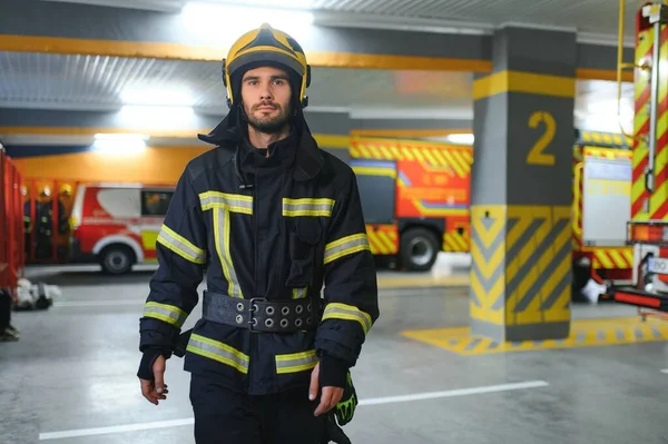 Portrait of male firefighter in uniform at fire station.