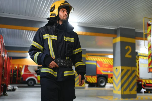 Portrait of male firefighter in uniform at fire station.