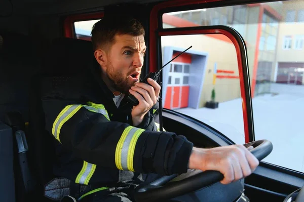 Firefighter using radio set while driving fire truck.
