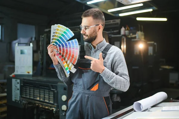 stock image Typographer standing with color swatches at the printing manufacturing.