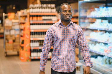 Çekici Afrikalı Amerikalı adam süpermarketten alışveriş yapıyor..