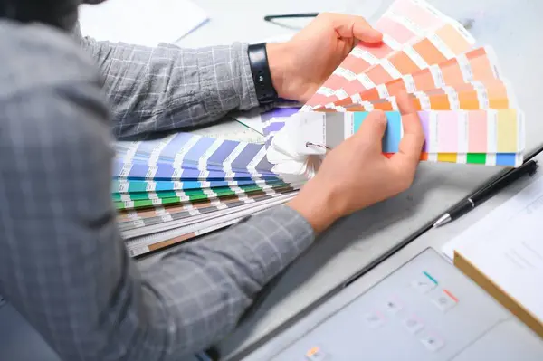 Typographer standing with color swatches at the printing manufacturing.