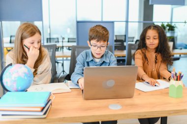 Akıllı kız öğrenciler ve sınıf içinde belgili tanımlık laptop bakarak çocuklarçok portre.