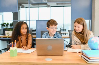 Okulda bir dizüstü bilgisayar için okul çocukları.