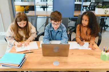 Akıllı kız öğrenciler ve sınıf içinde belgili tanımlık laptop bakarak çocuklarçok portre.