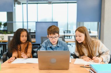 Okulda bir dizüstü bilgisayar için okul çocukları.