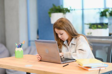 Gülümseyen küçük beyaz kızın öğretmeniyle uzaktan konuşma videosu var..