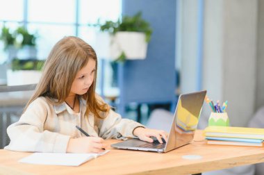 Gülümseyen küçük beyaz kızın öğretmeniyle uzaktan konuşma videosu var..