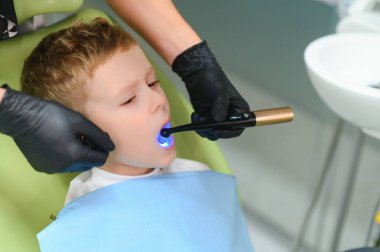 Scared red-haired boy crying at reception at dentist in dental chair. Pediatric dentistry.