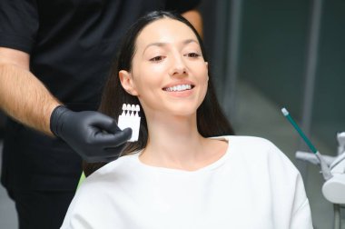 Kontrol ve genç kadının diş rengini seçerek diş hekimi.