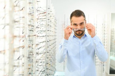 Adam görüş düzeltmesi için göz doktorunda gözlük seçiyor. Görüş düzeltmesi için gözlük.