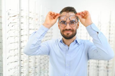 Müşteri memnuniyeti. Yeni gözlük takan mutlu genç erkek müşteri manzarası.