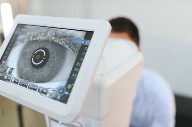 Yakışıklı genç modern göz hastalıkları Kliniği göz imgelemde kontrol ediyor. Hastada göz hastalıkları Kliniği.