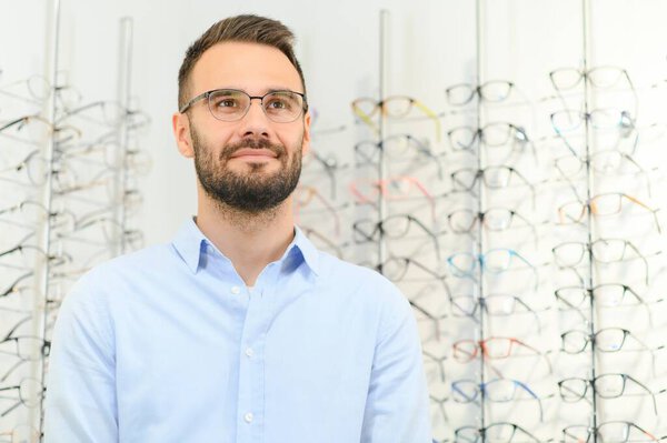 Glasses Shop. Man Trying On Eyeglasses In Optics Store.