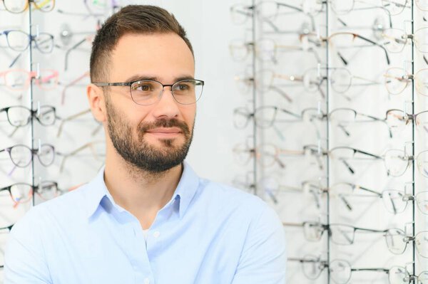 Man choosing glasses in eyewear store.