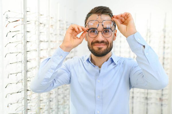 Glasses Shop. Man Trying On Eyeglasses In Optics Store.