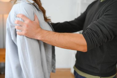 Kavga, şiddet ve koca evde karısını dövüyor. Kızgın adam korkmuş kadına yumruk sallıyor.