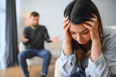 Tahriş olmuş koca karısına şiddet ile bağırıyor. Kadın korkuyla yüzünü kaplayan.