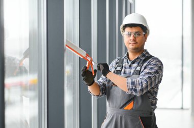 İşçi odaya bir pencere çerçevesi yerleştirir.
