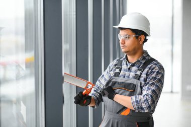 İşçi odaya bir pencere çerçevesi yerleştirir.