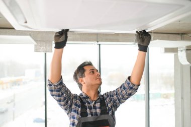 Yoğunlaşmış genç Hintli mühendis klima kuruyor.