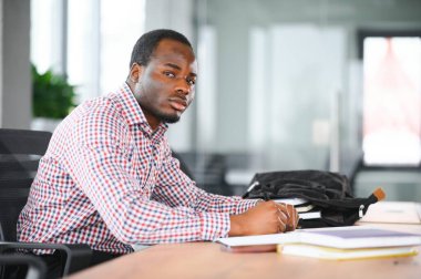 Sınıfta kameraya bakan Afrikalı üniversite öğrencisinin portresi.