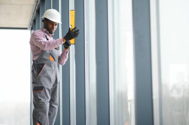İnşaat işçisi plastik pencereyi tornavidayla tamir ediyor. Pankart tasarımı