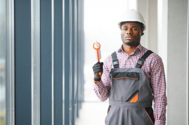 Tulum pencere yüklerken bir genç Afrika tamirci düşük açılı görünümü.