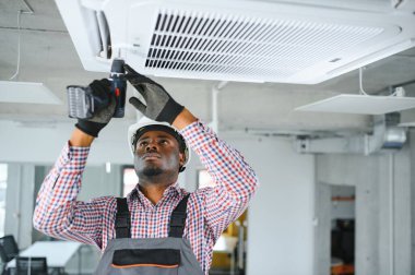 Mutlu genç Afrika erkek teknisyen Klima tamiri.