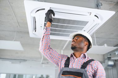 Mutlu genç Afrika erkek teknisyen Klima tamiri.