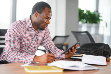 Sınıfta oturan Afrikalı öğrenci. Lisedeki derste erkek öğrenci.