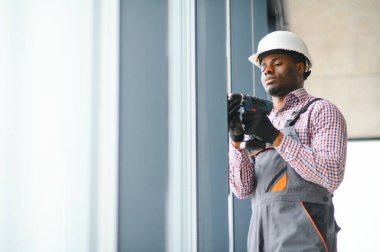 İnşaat işçisi plastik pencereyi tornavidayla tamir ediyor. Pankart tasarımı