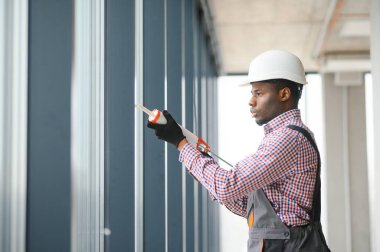 Tulum pencere yüklerken bir genç Afrika tamirci düşük açılı görünümü.