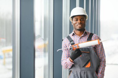 Evdeki oturma odasına plastik pencereler monte eden ya da ayarlayan işçi