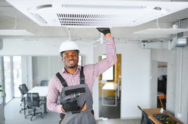 Profesyonel bir tamirci odaya klima kuruyor..